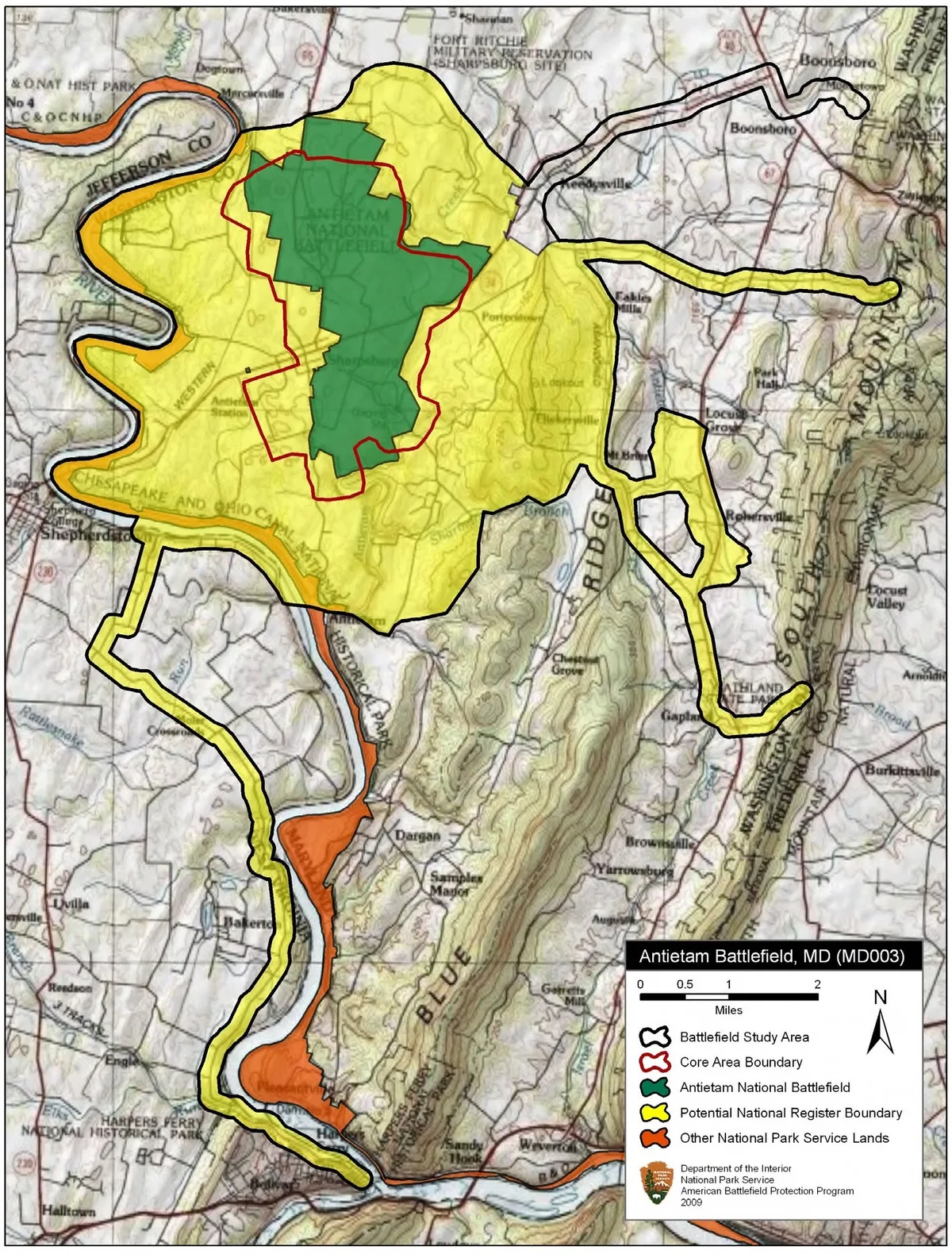 A colorful battlefield map fills the frame, with Antietam’s core area highlighted in green and surrounding study, park, and boundary zones outlined in yellow, red, and orange. The topographic base map shows the ridges, roads, towns, and the Potomac River around Sharpsburg, Boonsboro, and Harpers Ferry.