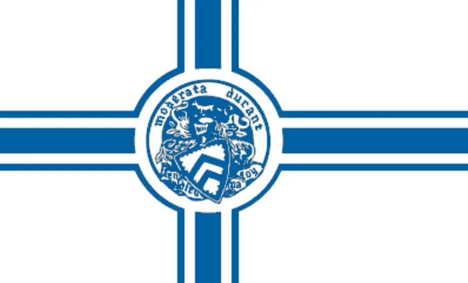 A white flag with a bold blue cross and double stripes centers on Staunton’s circular seal, showing a detailed blue emblem with the motto “Montivata Ardua.” The simple, graphic design stands out crisply against the plain background.